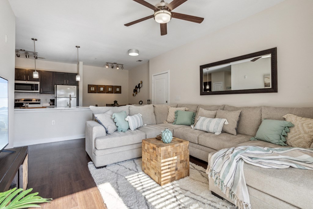 the living room and kitchen of a manufactured home with a large couch at Hampton Roads Crossing, Suffolk, VA, 23435