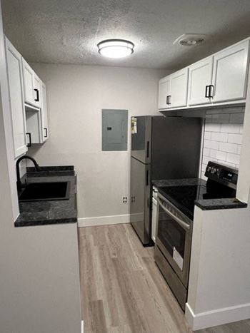 a kitchen with a stove a refrigerator and a sink