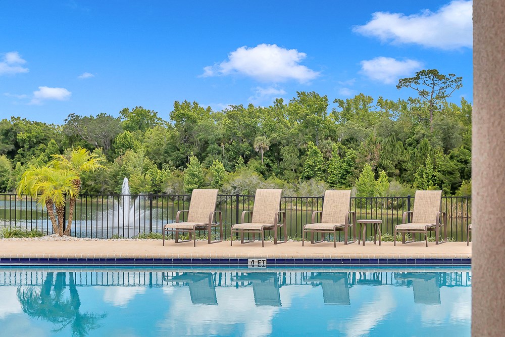 Pool with lake view at Bermuda Estates Apartments in Ormond Beach, FL