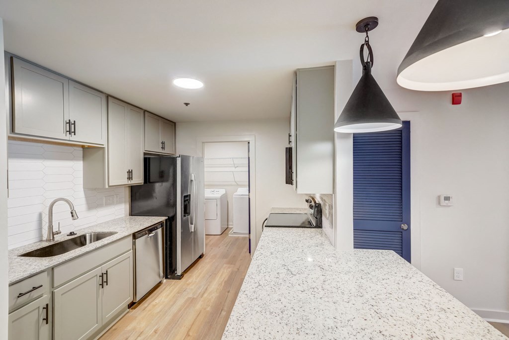 a renovated kitchen with white cabinets and a white counter top