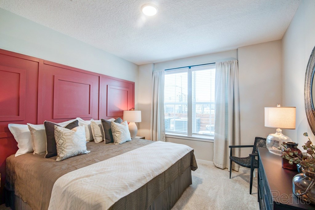 Bedroom with double window and ensuite bathroom. Bedroom with double window and ceiling fan at Tapestry Nona in Orlando, FL