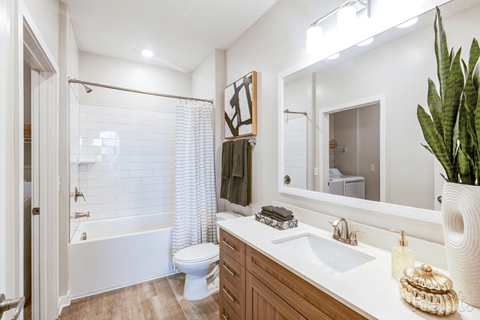 A bathroom with a white tub, toilet, and sink.
