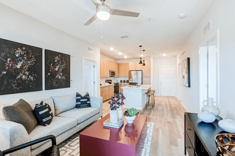 A living room with a couch, a coffee table, and a ceiling fan.