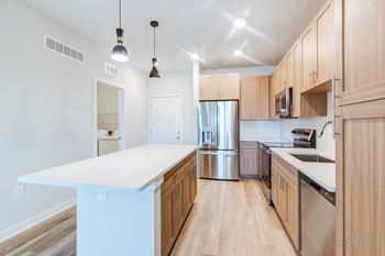 A kitchen with wooden cabinets and a white island.