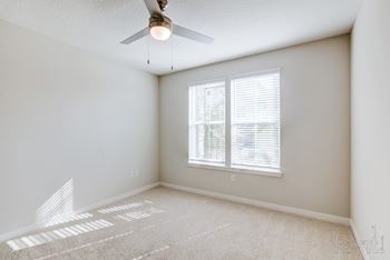 A room with a window and a fan.