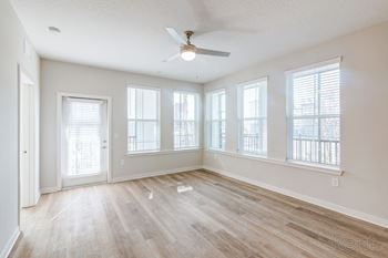 Oversized living room with natural light, wood floors, and ceiling fan at Tapestry Nona Apartments in Orlando, FL