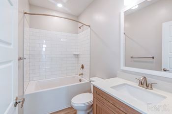 A white bathroom with a toilet, sink, and bathtub.