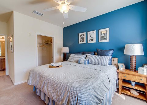 A bedroom with a bed, nightstand, and lamp.