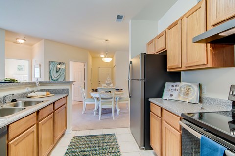 A kitchen with wooden cabinets and a black refrigerator.