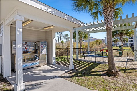 A white building with a sign that says "POOL WASH" is under a white pergola.