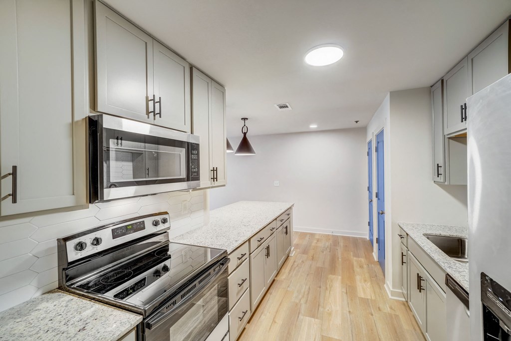a kitchen with white cabinets and stainless steel appliances