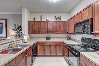 Black appliances and tile floor in kitchen at Bermuda Estates Apartments in Ormond Beach, FL Large kitchen with double sinks at Bermuda Estates Apartments in Ormond Beach, FL