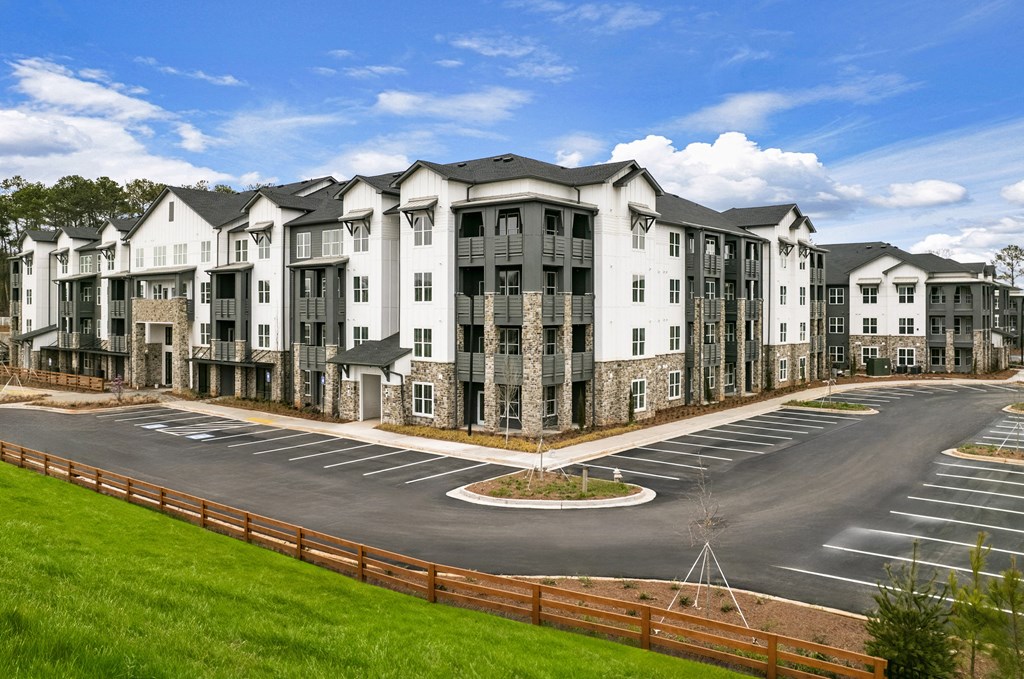 an exterior view of an apartment building in a parking lot at Tapestry Overbrook in McDonough, Georgia