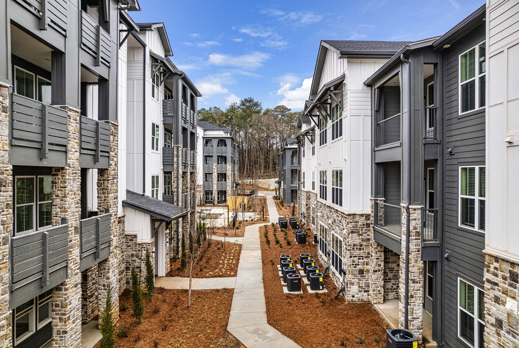 an aerial view of a row of apartment buildings on a dirt road