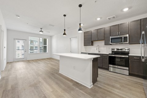 an open kitchen and living room with a large white counter top