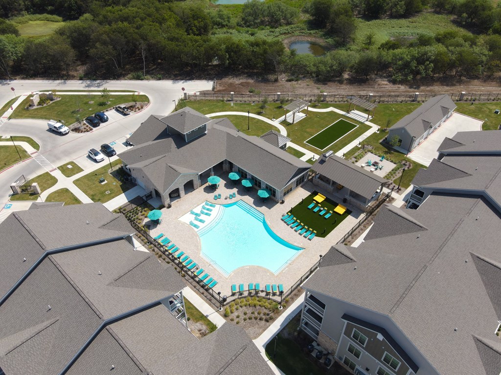 an aerial view of the resort style pool and tennis courts