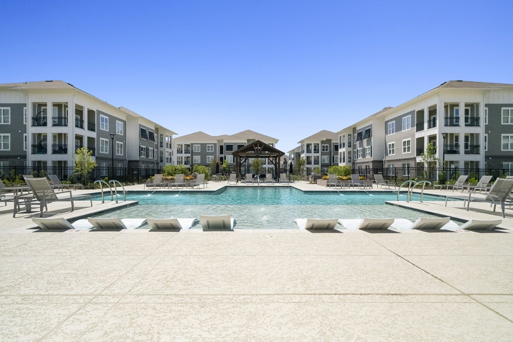 a large swimming pool in front of an apartment building