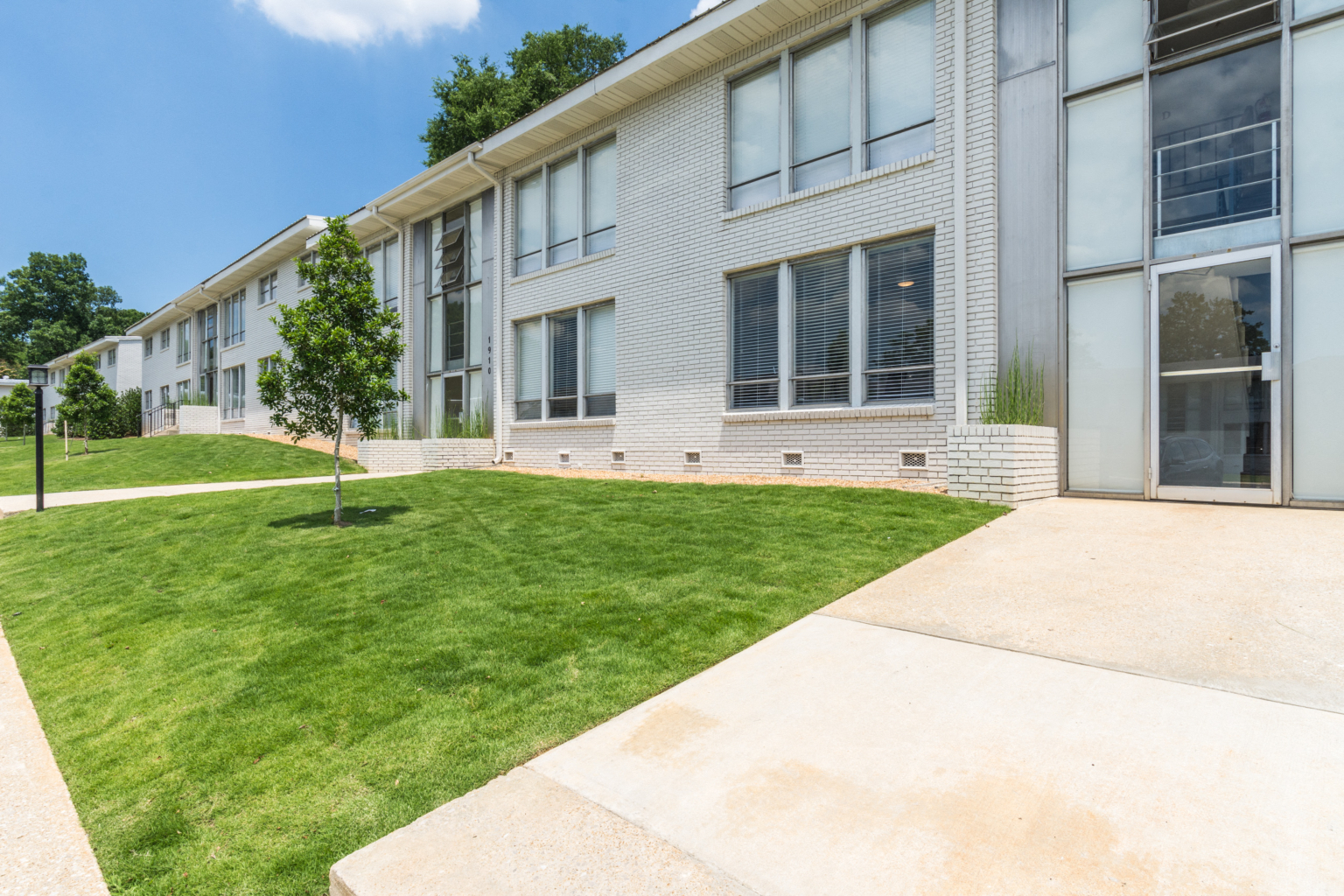 an exterior view of a building with grass and a sidewalk