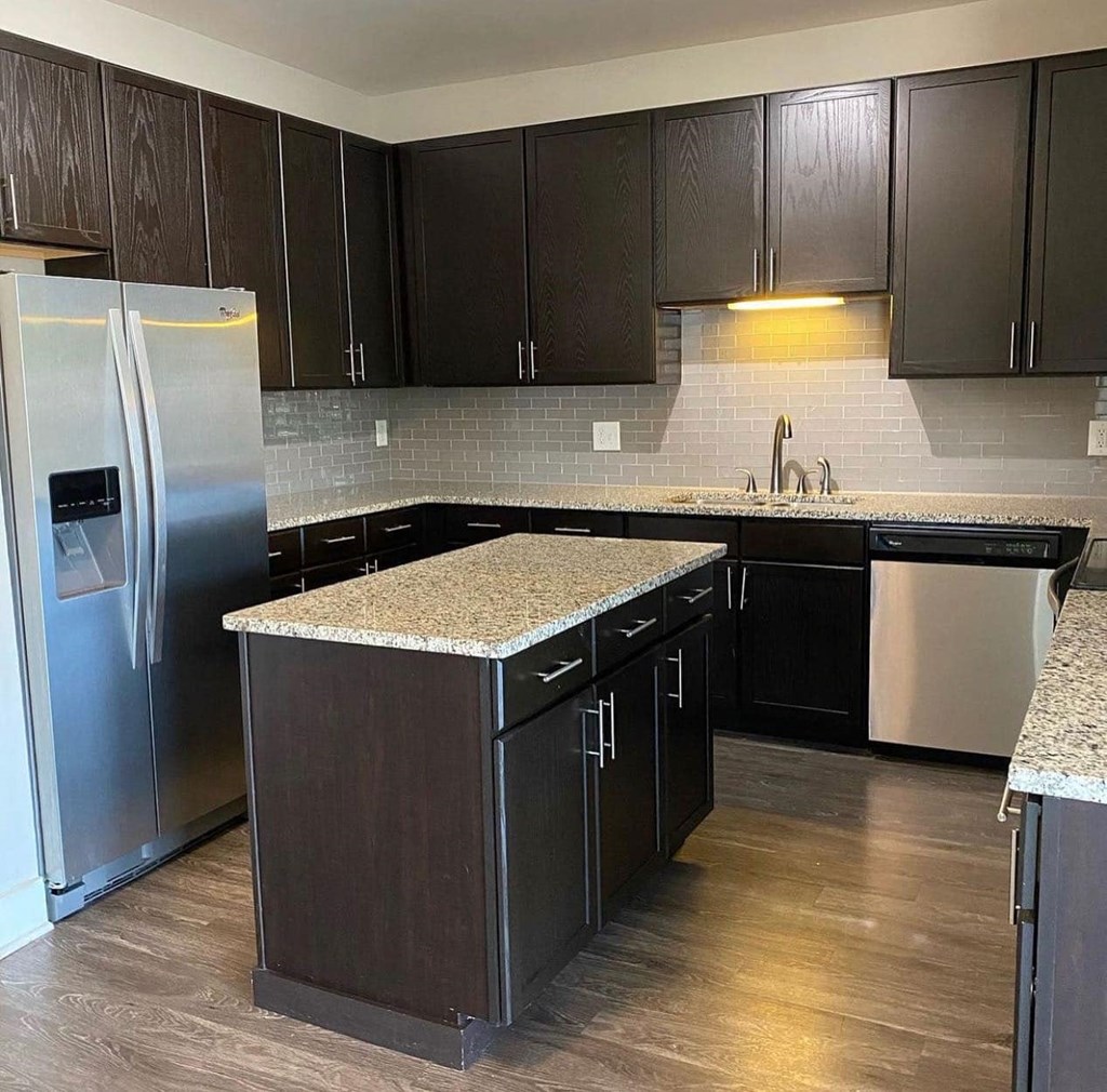 Modern kitchen with backsplash and island at Flats on 4th Apartments in Birmingham, AL