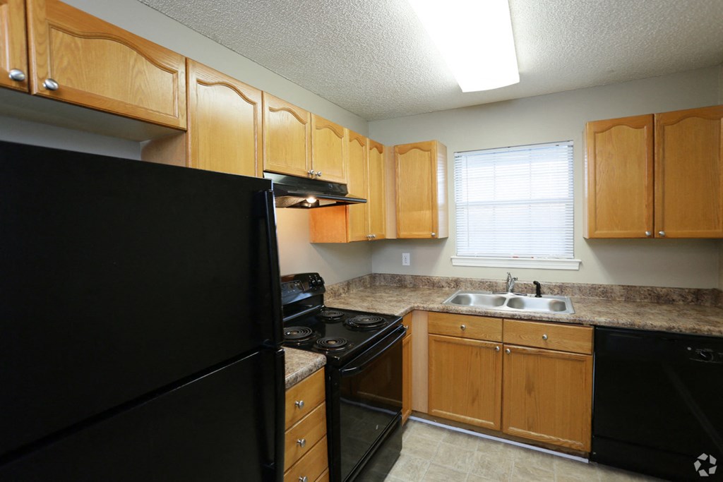 a kitchen with black appliances and wooden cabinets