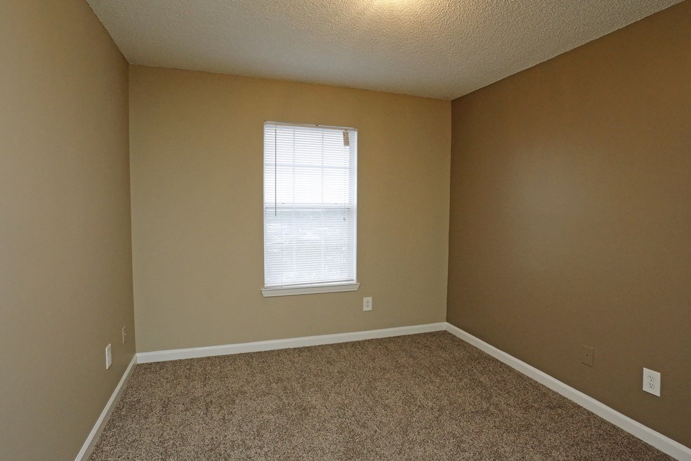 an empty room with carpet and a window