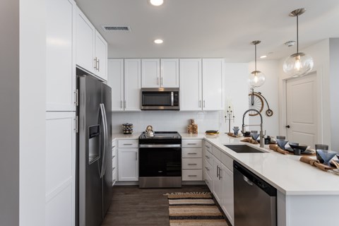 A modern kitchen with white cabinets and stainless steel appliances.