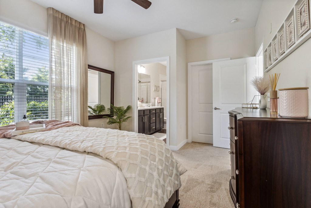 a bedroom with a bed and a dresser and a bathroom at Hampton Roads Crossing, Virginia