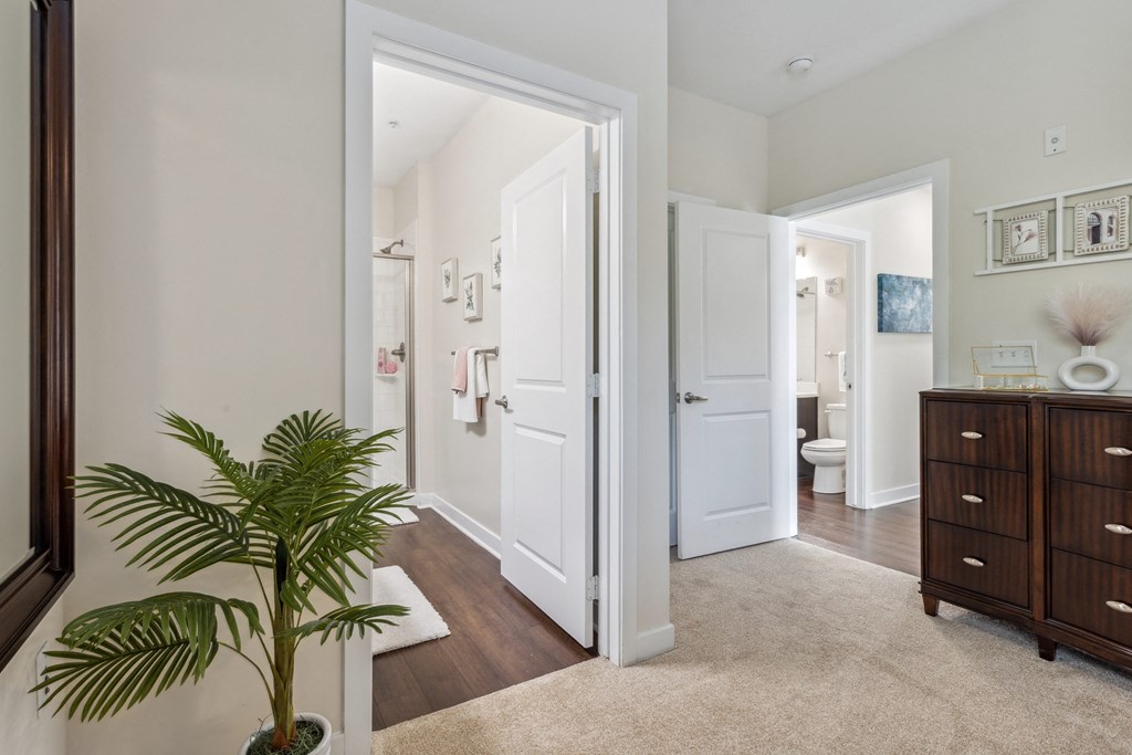 a living room with a potted plant and a door to a bathroom at Hampton Roads Crossing, Suffolk, 23435