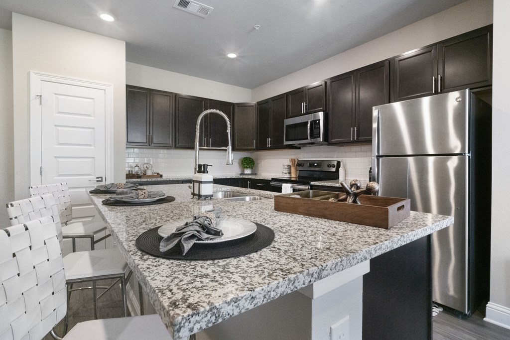 a kitchen with stainless steel appliances and granite counter tops
