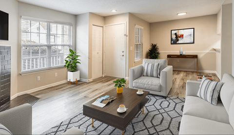 A living room with a grey couch, a coffee table, and a plant.