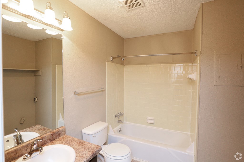 a bathroom with a tub and a sink and a toilet