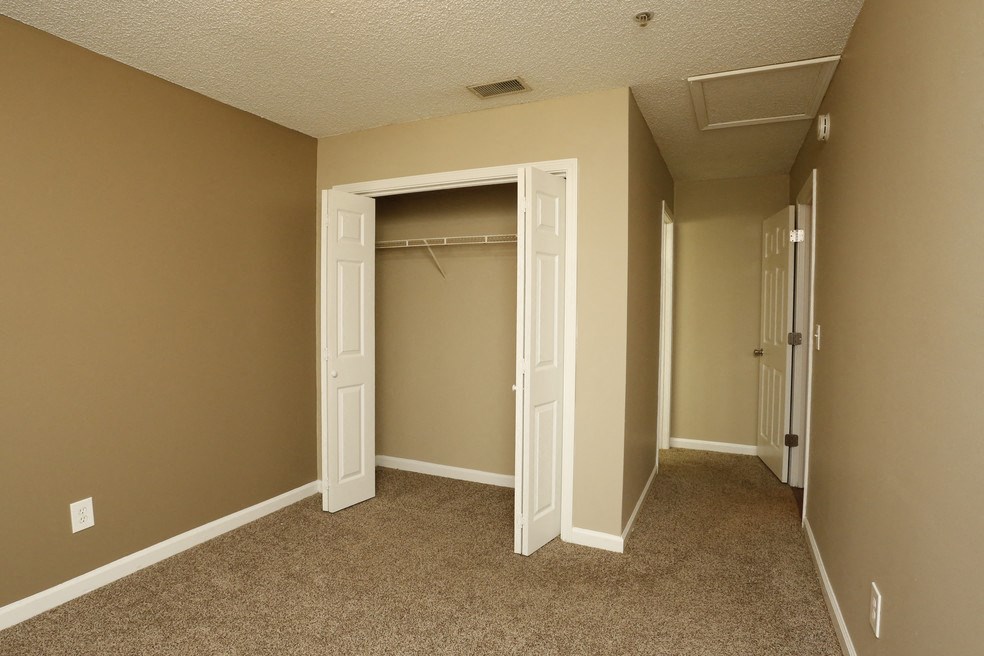 an empty bedroom with a closet and a closet door open