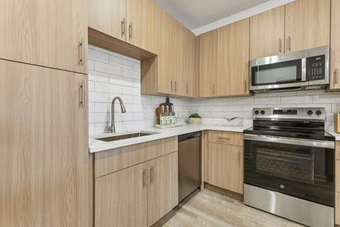 A kitchen with wooden cabinets and stainless steel appliances.