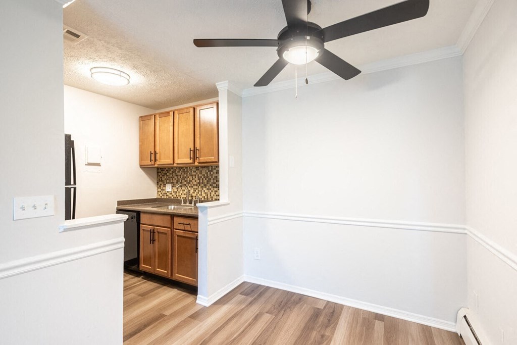an empty kitchen with a ceiling fan