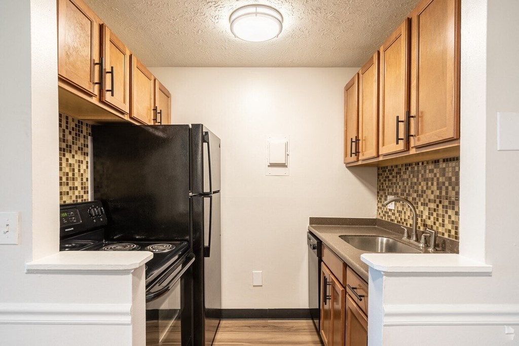 a kitchen with black appliances and wooden cabinets