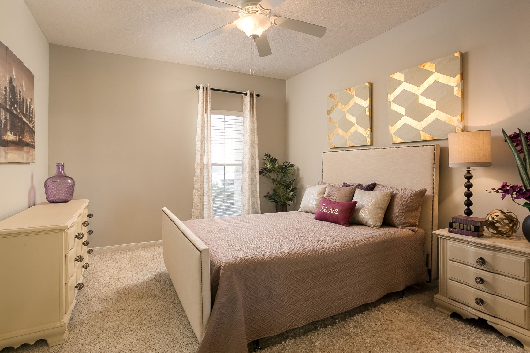 Primary bedroom with window and carpet at Village at Caldwell Mill Apartments in Birmingham, Alabama