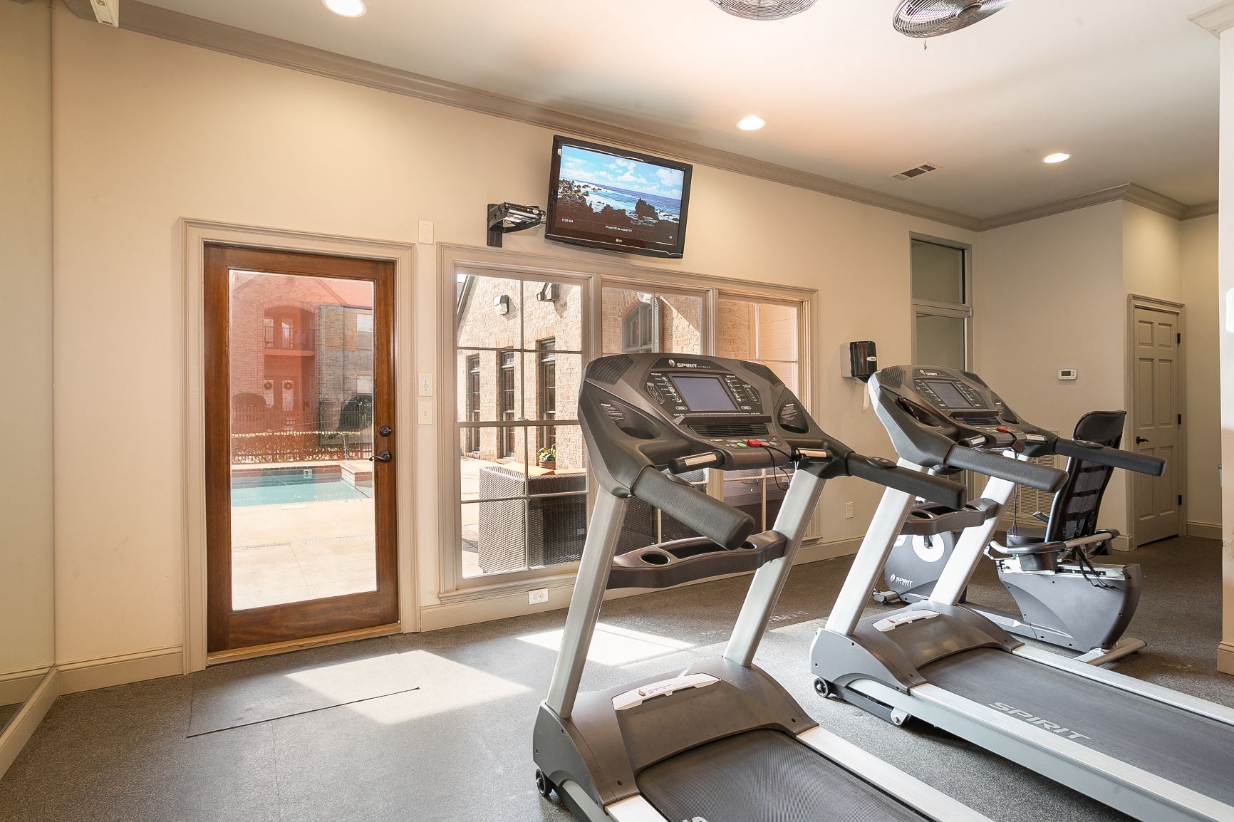 fitness room that overlooks pool at Village at Caldwell Mill Apartments in Birmingham, Alabama