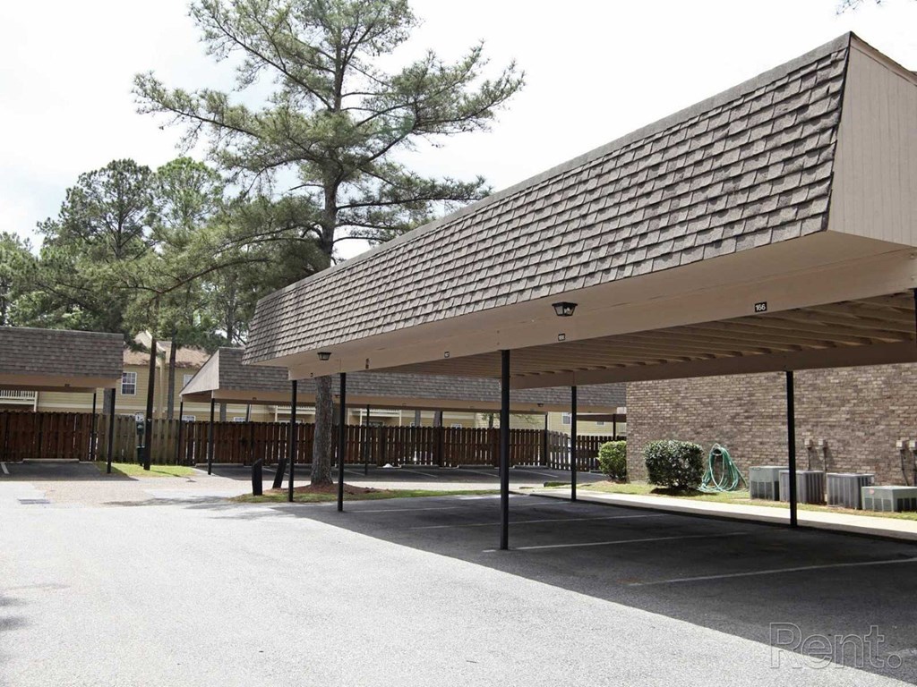 A parking lot with a long covered parking area The Oakley at Hillcrest in Mobile, AL.