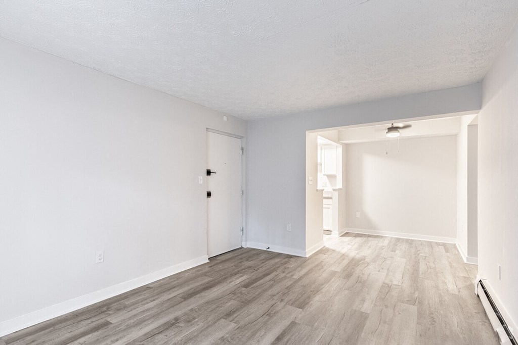 a bedroom with hardwood floors and white walls