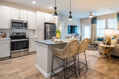 an open kitchen and living room with an island and a table with chairs