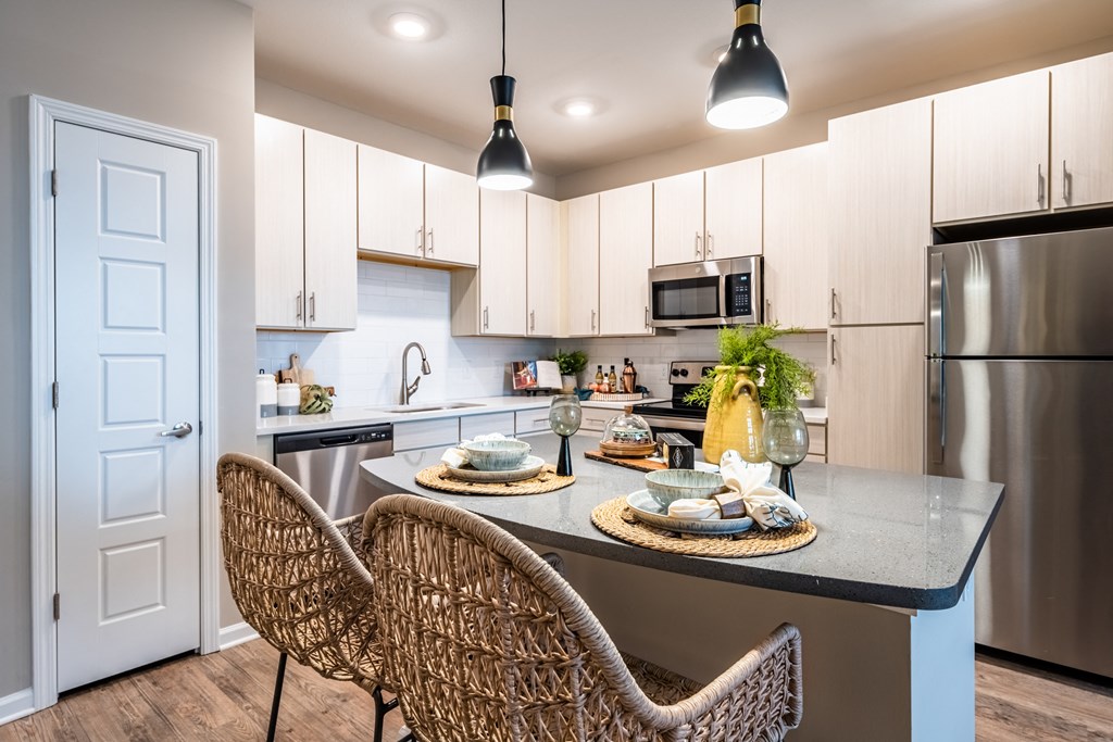 kitchen with white cabinets and stainless steel appliances at the enclave at woodbridge apartments in sugar land