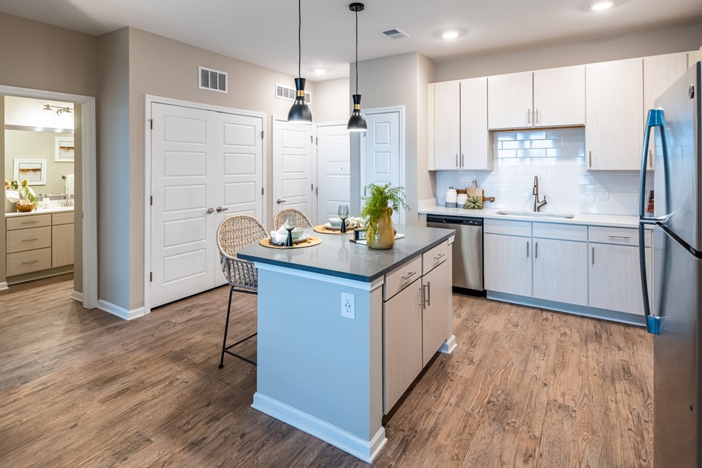 a kitchen with white cabinets and a blue island