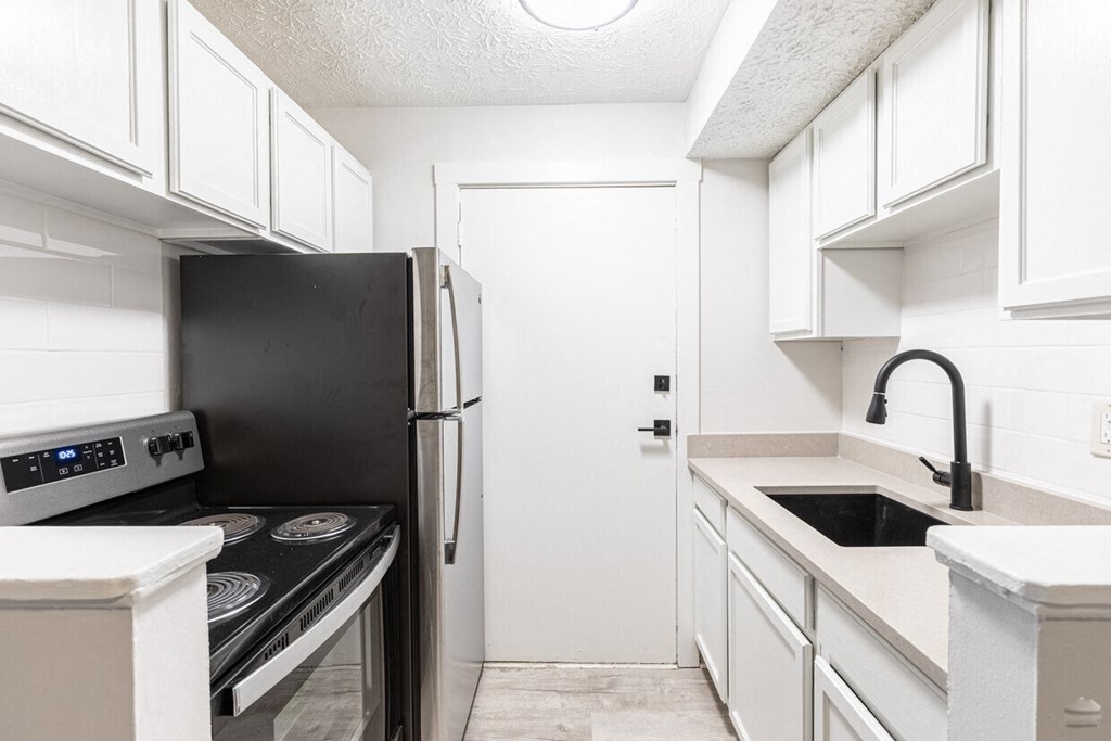 a kitchen with white cabinetry and black appliances