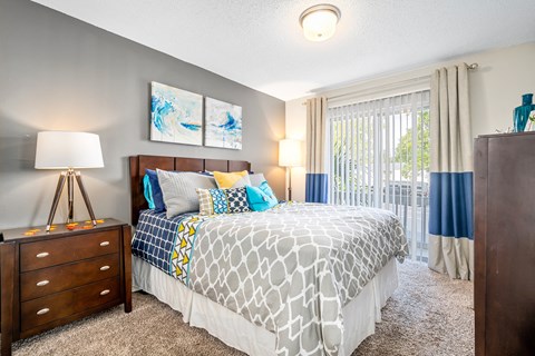 spacious primary bedroom with direct access to private patio or balcony at 701 South Apartments in Mobile, AL