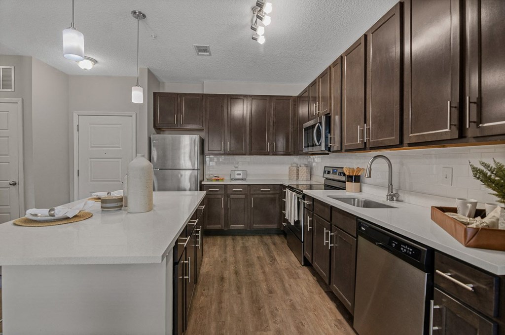 an empty kitchen with wooden cabinets and stainless steel appliances