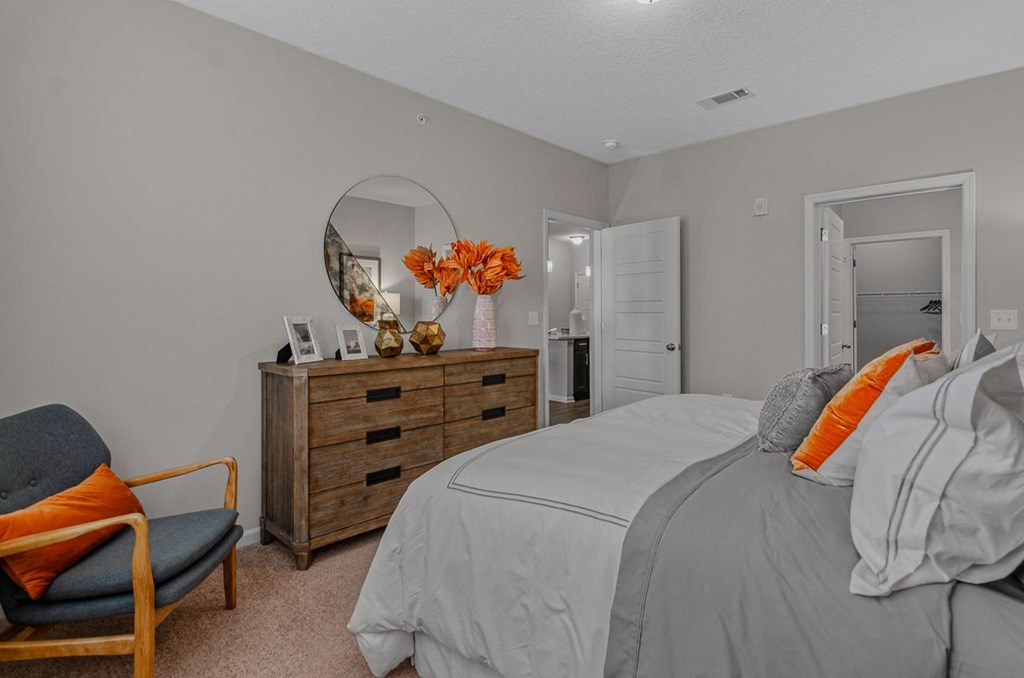 a bedroom with a bed and a dresser and a mirror