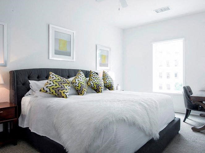 a white bedroom with a bed with pillows on it