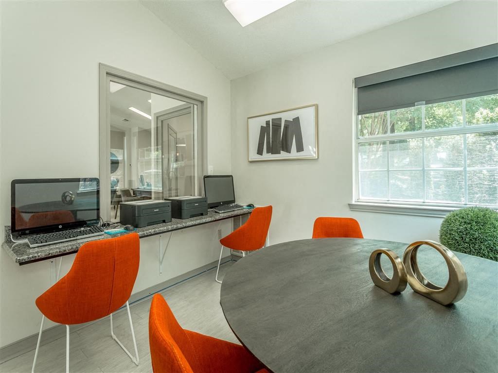 a conference room with a round table and orange chairs