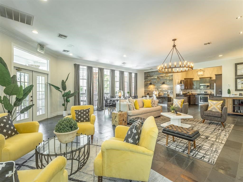 a living room with yellow couches and chairs and a kitchen