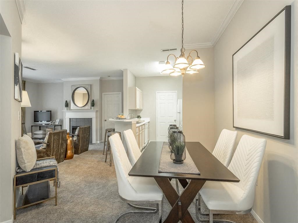 a living room and dining room with a table and chairs
